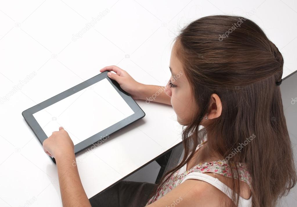 Beaitiful pre-teen girl using a tablet computer.