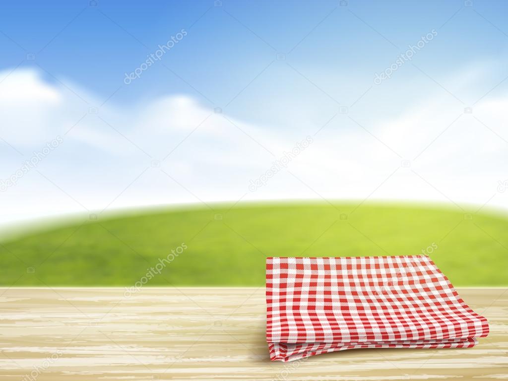 closeup of wooden desk and tablecloth over blue sky