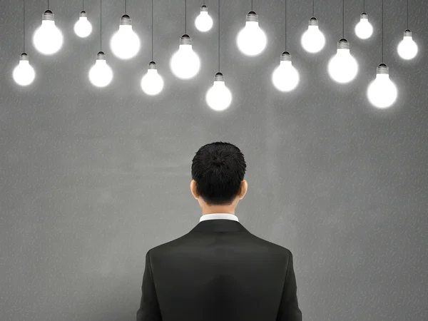 Homme d'affaires avec ampoules suspendues — Image vectorielle