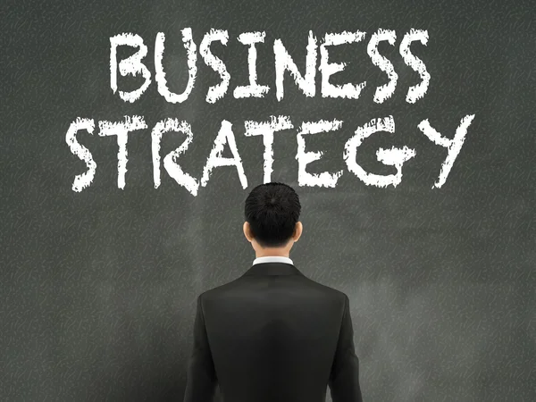 Бізнесмен дивиться на слова бізнес-стратегії — стоковий вектор