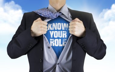 businessman showing Know your role words underneath his shirt  clipart