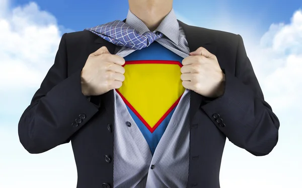 Businessman showing superhero icon underneath his shirt — Stock Photo, Image