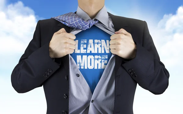 Businessman showing Learn more words underneath his shirt — Stock Photo, Image