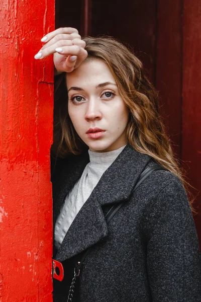 Linda Menina Encaracolado Fica Perto Porta Vermelha Casaco Preto — Fotografia de Stock