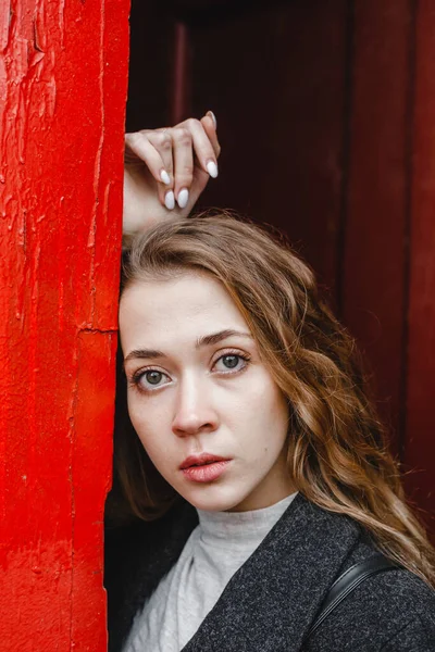 Linda Menina Encaracolado Fica Perto Porta Vermelha Casaco Preto — Fotografia de Stock