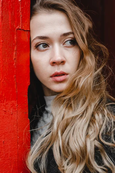 Linda Menina Encaracolado Fica Perto Porta Vermelha Casaco Preto — Fotografia de Stock