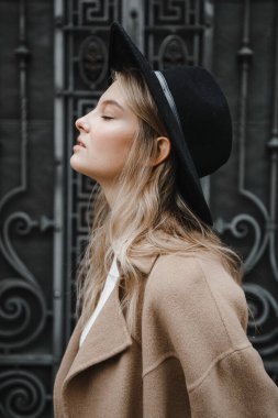 Kahverengi ceketli, siyah şapkalı, gülümseyen, üzgün