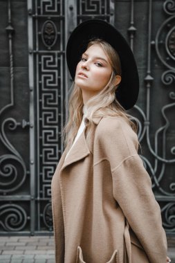 Kahverengi ceketli, siyah şapkalı, gülümseyen, üzgün