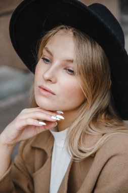 Kahverengi ceketli, siyah şapkalı, gülümseyen, üzgün