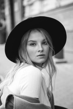 Kahverengi ceketli, siyah şapkalı, gülümseyen, üzgün