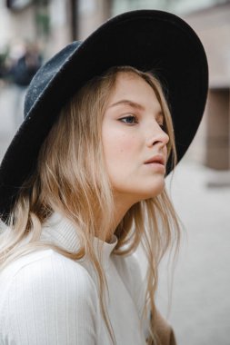 Kahverengi ceketli, siyah şapkalı, gülümseyen, üzgün