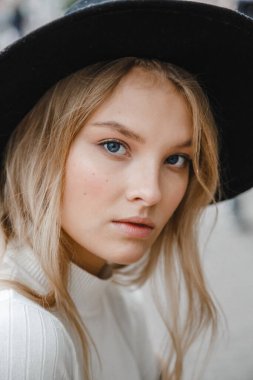 Kahverengi ceketli, siyah şapkalı, gülümseyen, üzgün