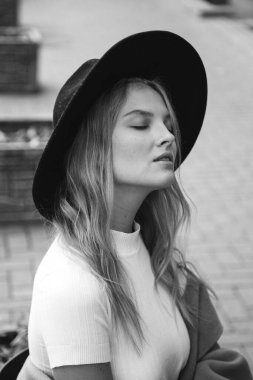 Kahverengi ceketli, siyah şapkalı, gülümseyen, üzgün