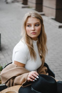 Kahverengi ceketli, siyah şapkalı, gülümseyen, üzgün