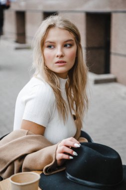 Kahverengi ceketli, siyah şapkalı, gülümseyen, üzgün