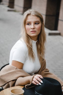 Kahverengi ceketli, siyah şapkalı, gülümseyen, üzgün