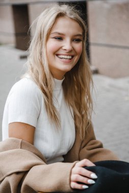 Kahverengi ceketli, siyah şapkalı, gülümseyen, üzgün