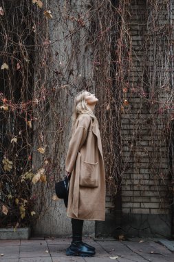 Kahverengi ceketli, siyah şapkalı, gülümseyen, üzgün