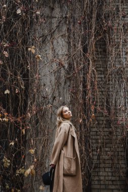 Kahverengi ceketli, siyah şapkalı, gülümseyen, üzgün