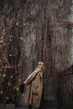 Kahverengi ceketli, siyah şapkalı, gülümseyen, üzgün