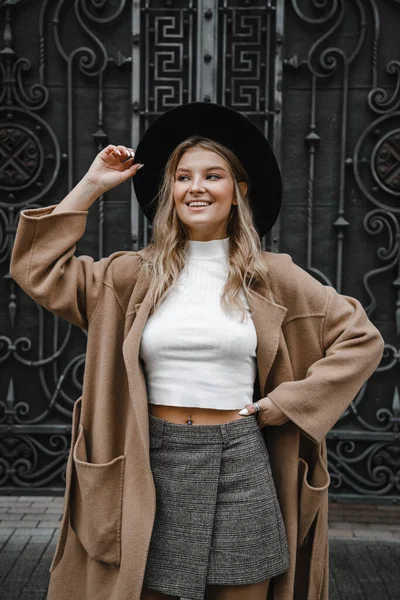 Blondýnka Hnědém Kabátě Černým Kloboukem Pózující Usmívající Rozrušená — Stock fotografie