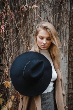 Kahverengi ceketli, siyah şapkalı, gülümseyen, üzgün