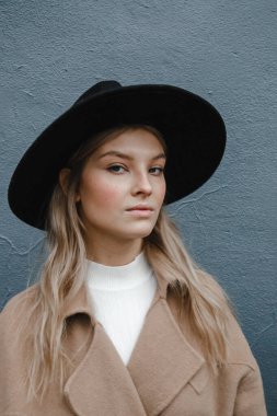 Kahverengi ceketli, siyah şapkalı, gülümseyen, üzgün