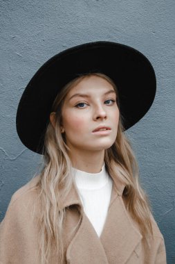 Kahverengi ceketli, siyah şapkalı, gülümseyen, üzgün