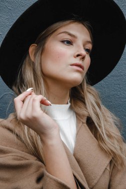 Kahverengi ceketli, siyah şapkalı, gülümseyen, üzgün