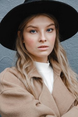 Kahverengi ceketli, siyah şapkalı, gülümseyen, üzgün