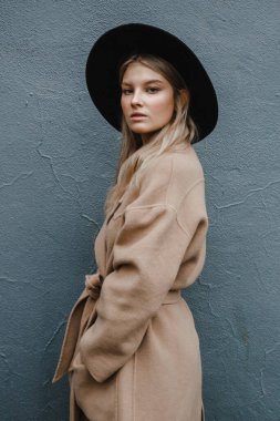 Kahverengi ceketli, siyah şapkalı, gülümseyen, üzgün