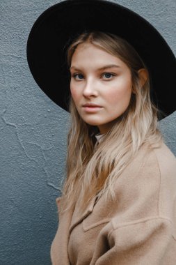 Kahverengi ceketli, siyah şapkalı, gülümseyen, üzgün