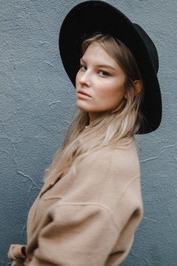 Kahverengi ceketli, siyah şapkalı, gülümseyen, üzgün