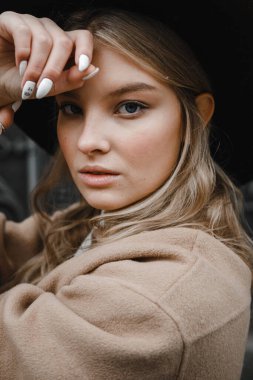 Kahverengi ceketli, siyah şapkalı, gülümseyen, üzgün