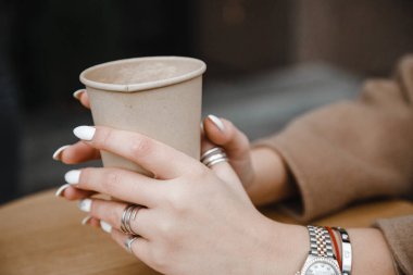 Kahverengi ceketli, siyah şapkalı, gülümseyen, üzgün