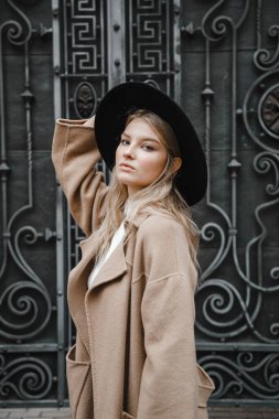 Kahverengi ceketli, siyah şapkalı, gülümseyen, üzgün