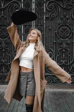 Kahverengi ceketli, siyah şapkalı, gülümseyen, üzgün