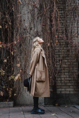 Kahverengi ceketli, siyah şapkalı, gülümseyen, üzgün