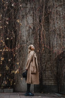 Kahverengi ceketli, siyah şapkalı, gülümseyen, üzgün