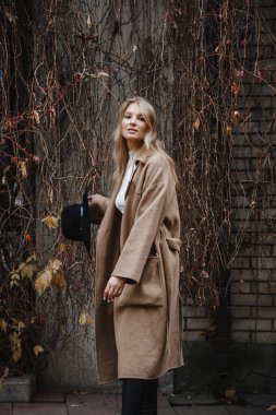 Kahverengi ceketli, siyah şapkalı, gülümseyen, üzgün