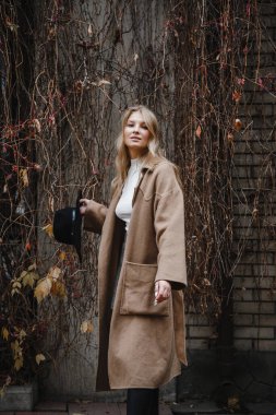 Kahverengi ceketli, siyah şapkalı, gülümseyen, üzgün