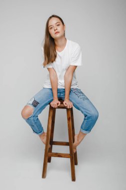 Model testleri. Sandalyeye oturup poz veren uzun saçlı güzel kız.