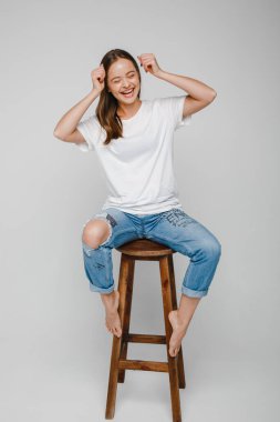 Model testleri. Sandalyeye oturup poz veren uzun saçlı güzel kız.