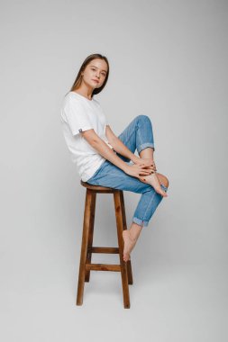 Model testleri. Sandalyeye oturup poz veren uzun saçlı güzel kız.