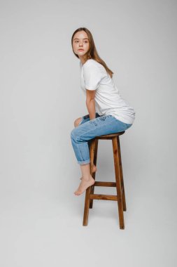 Model testleri. Sandalyeye oturup poz veren uzun saçlı güzel kız.