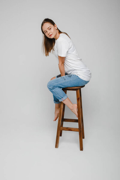 модельные испытания. Красивая девушка с длинными волосами сидит на стуле и позирует