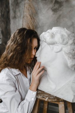 Güzel kıvırcık kız beyaz alçı kafayı öpüyor