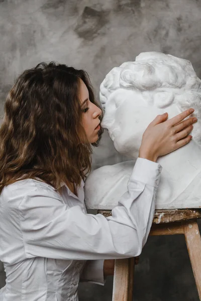 Beautiful Curly Girl Kissing White Plaster Head — Stock Photo, Image