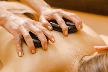 Taş terapisi. Şirin kıza taşlarla masaj yapılıyor.