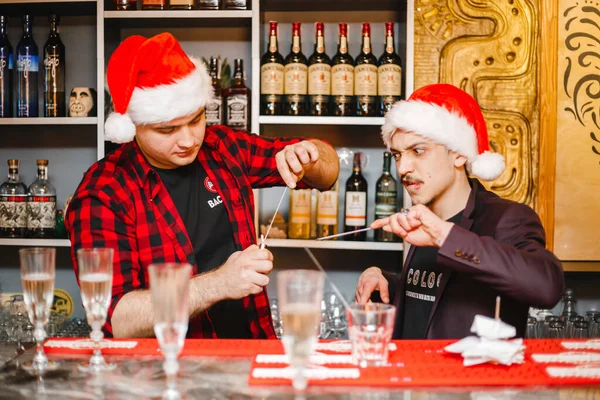 Due Baristi Cappelli Babbo Natale Stanno Dietro Bar Tengono Cocktail — Foto Stock